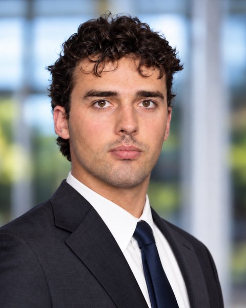 Shane Haynes in a dark suit and navy tie, looking straight at the camera